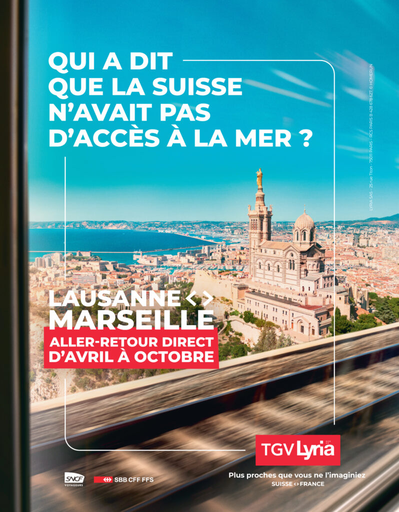 Vue aérienne de Marseille avec la basilique Notre-Dame de la Garde et la mer en arrière-plan, cadrée depuis une fenêtre de train