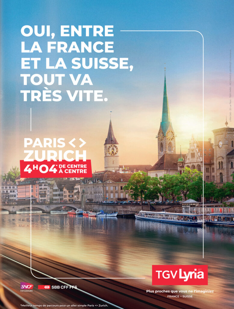 Vue de Zurich au coucher du soleil depuis une fenêtre de train, avec la rivière et les clochers de la vieille ville